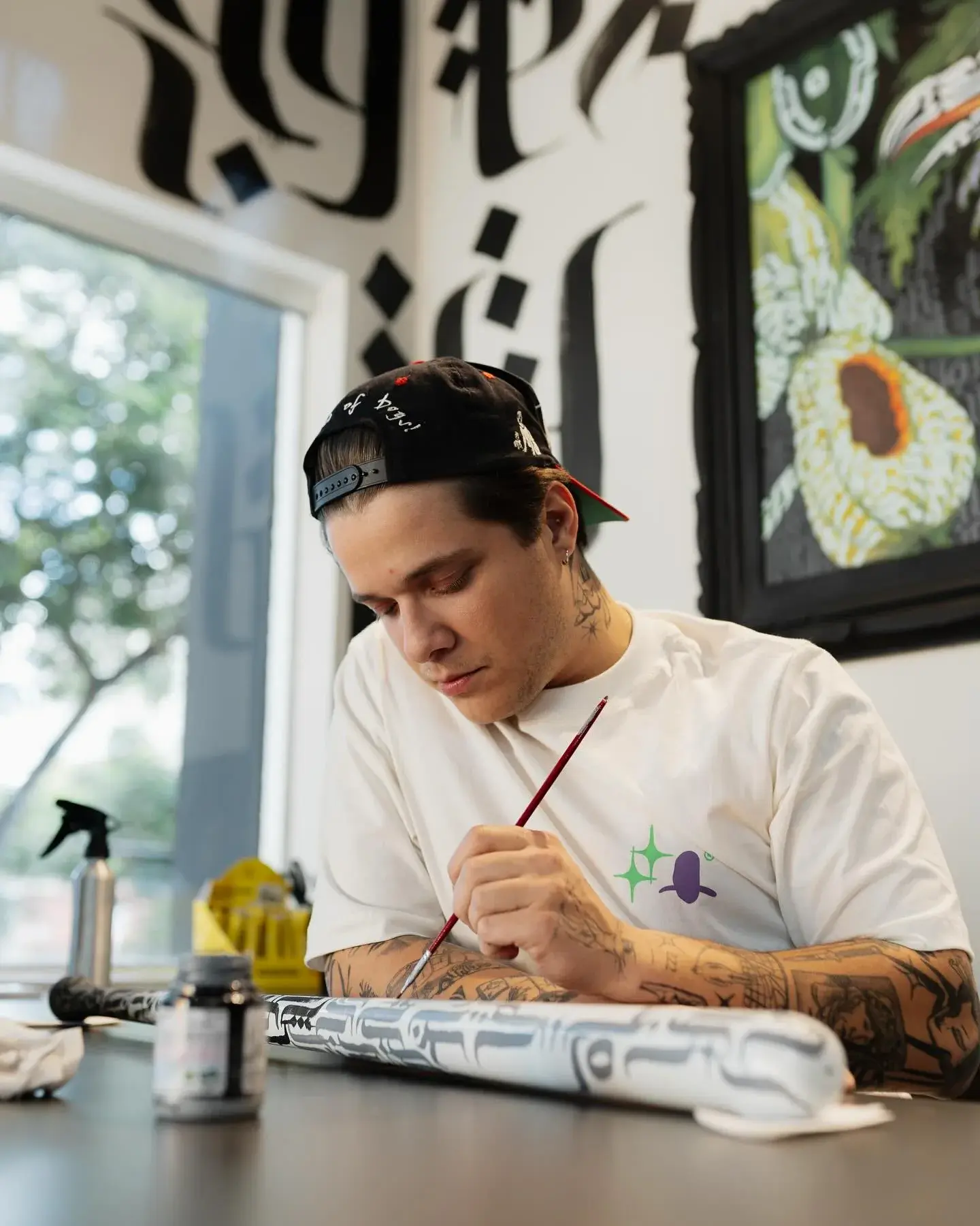 Gabriel pintando uma peça na bancada do estúdio