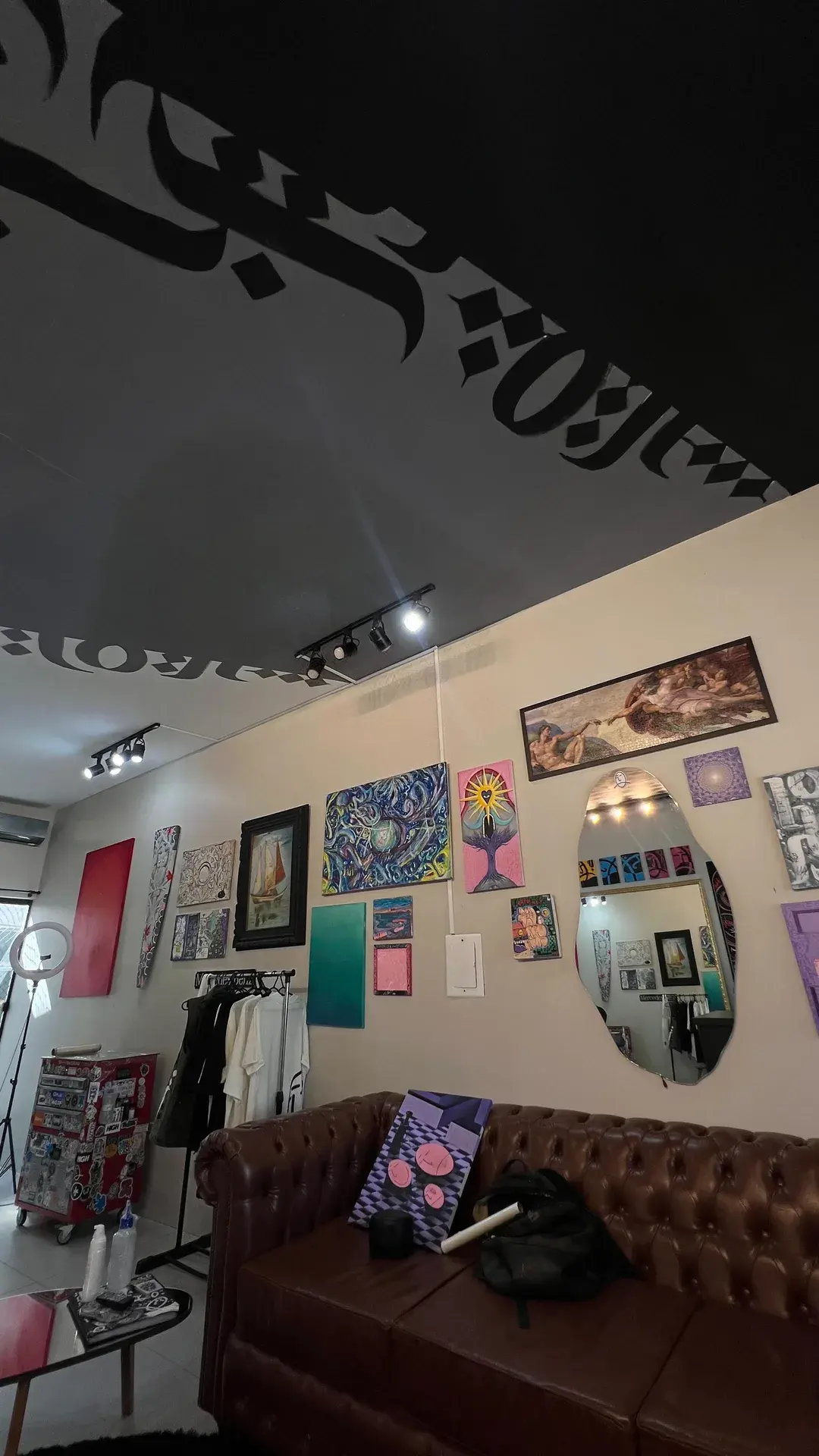 Interior do estúdio com telas e pinturas nas paredes