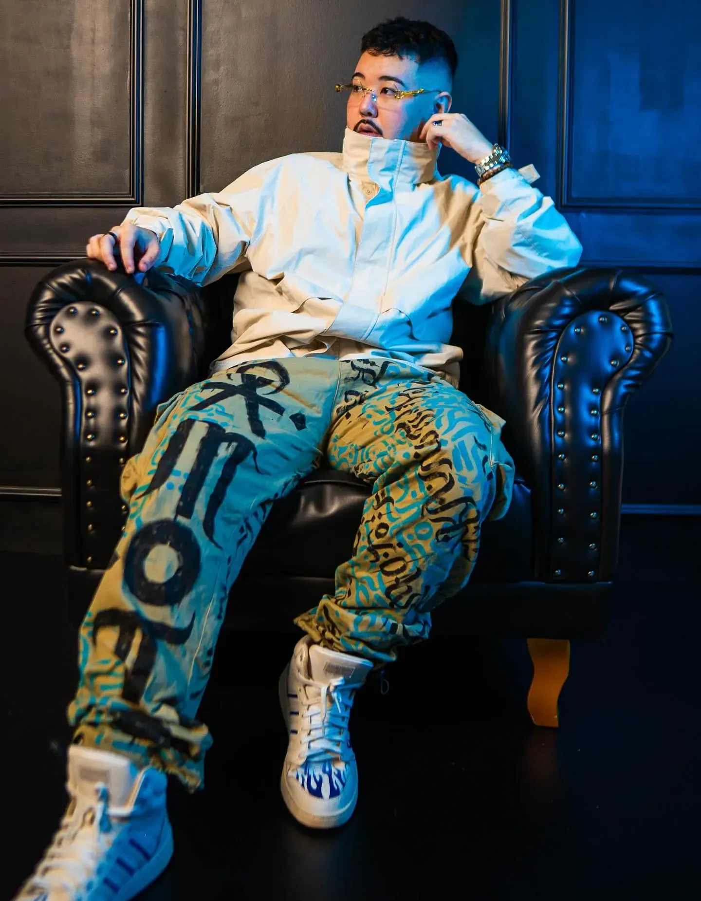 Gabriel em poltrona com calça e moletom pintados em azul