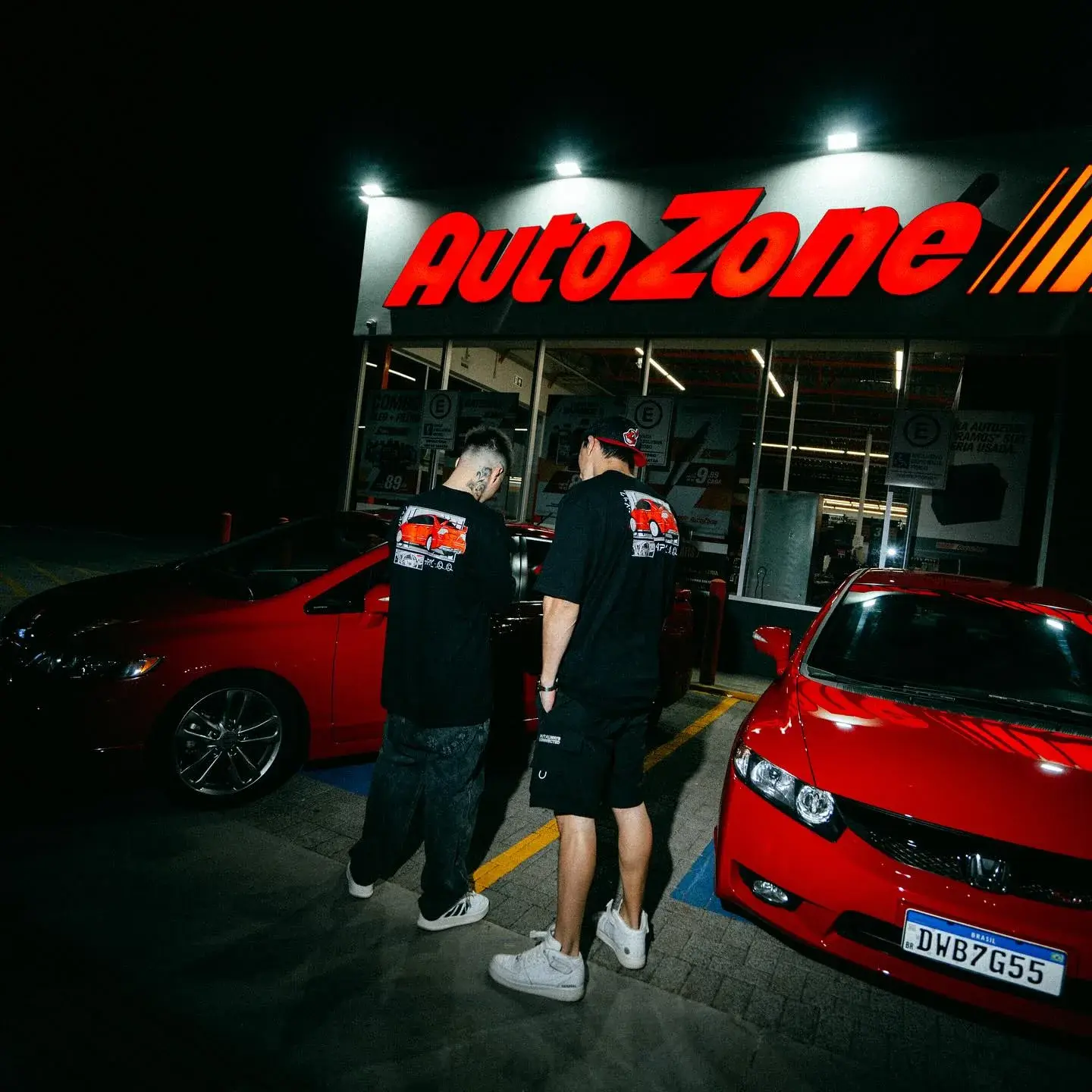 Ensaio noturno com carros vermelhos e camisetas da collab