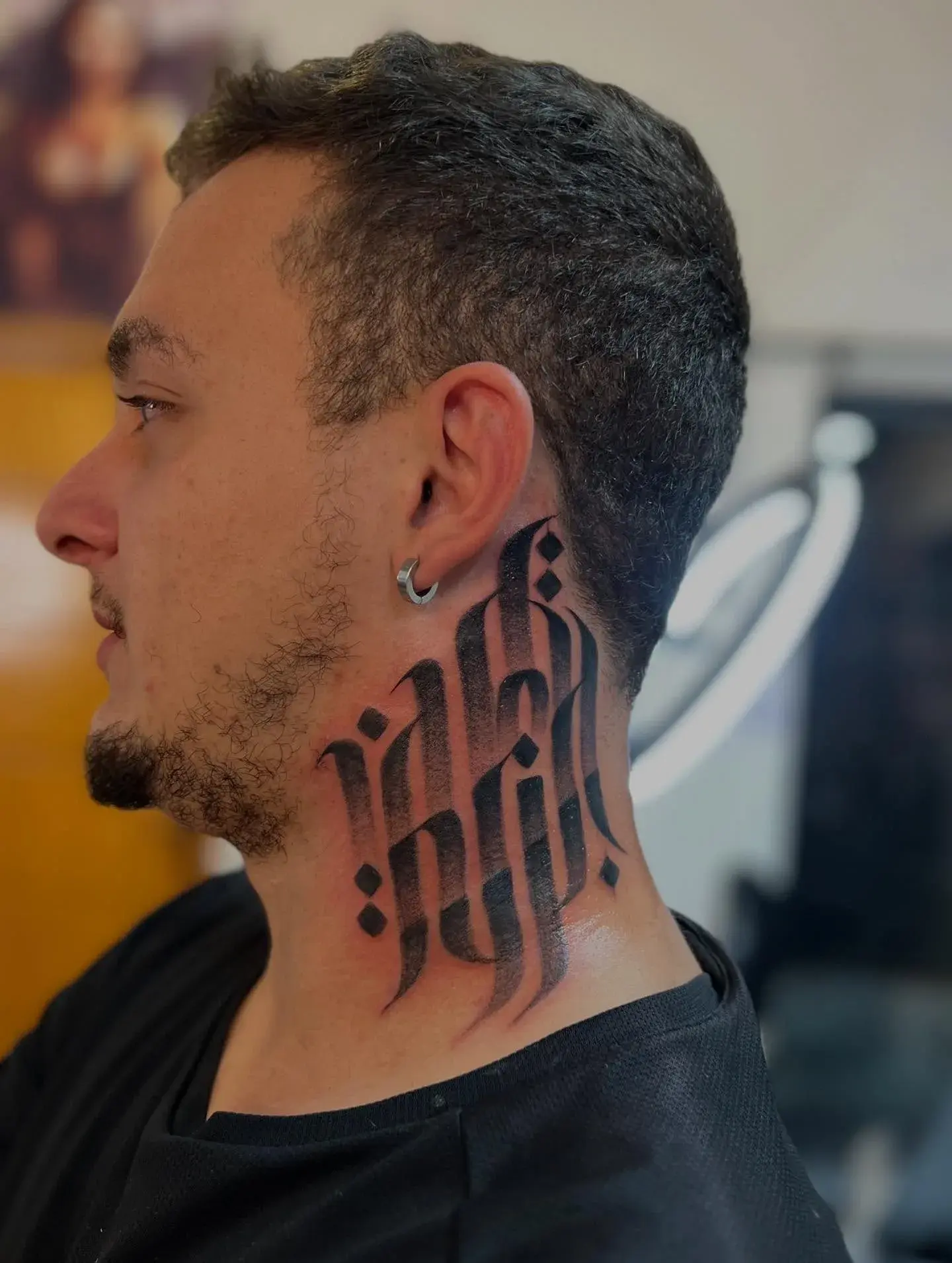 Gabriel de perfil diante da parede de caligrafia vermelha
