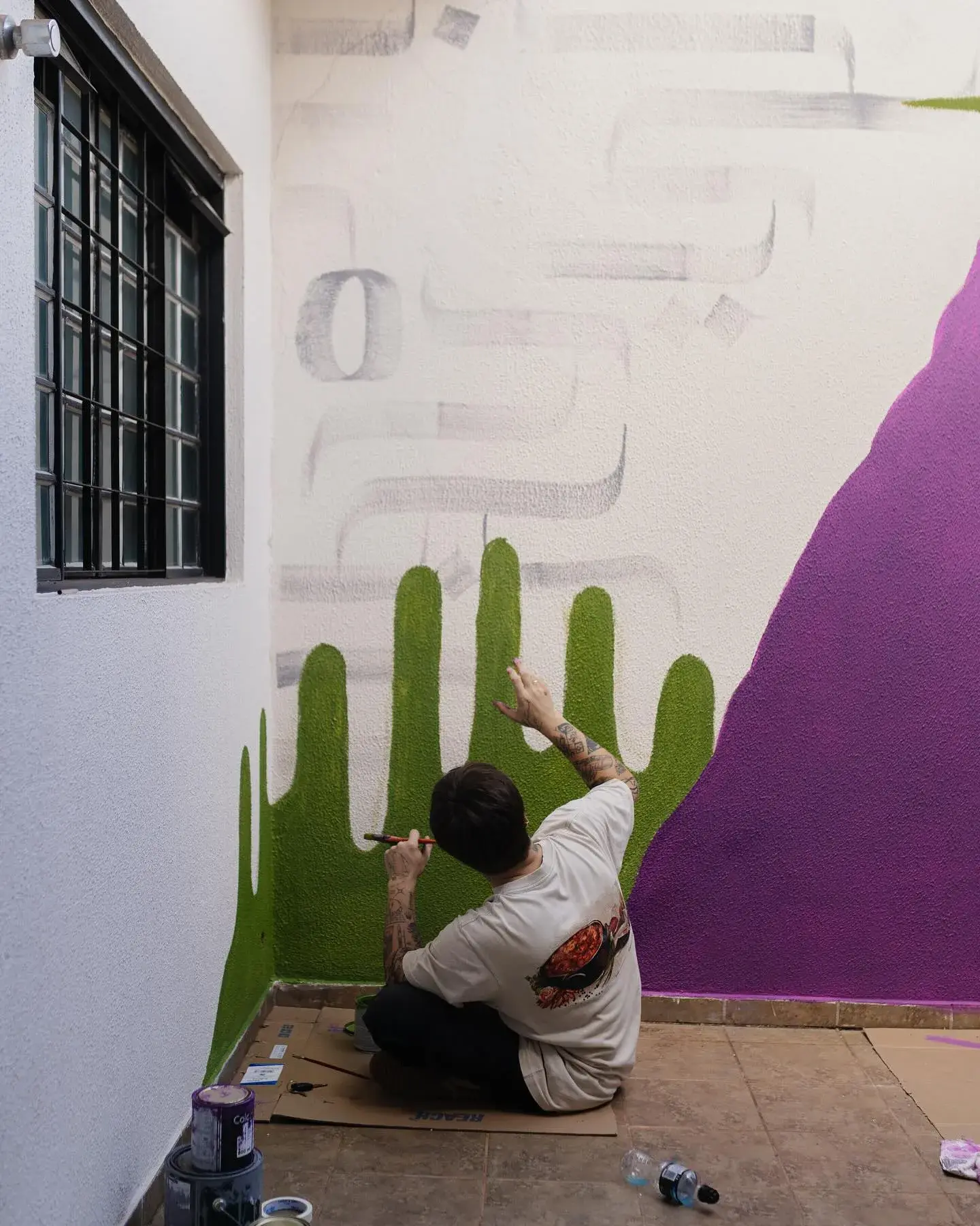 Gabriel pintando o mural colorido