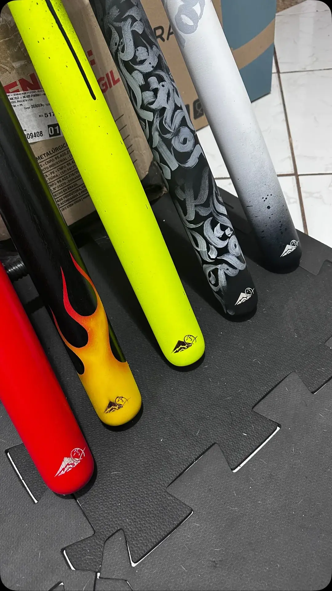 Tacos de baseball pintados em amarelo, vermelho e preto