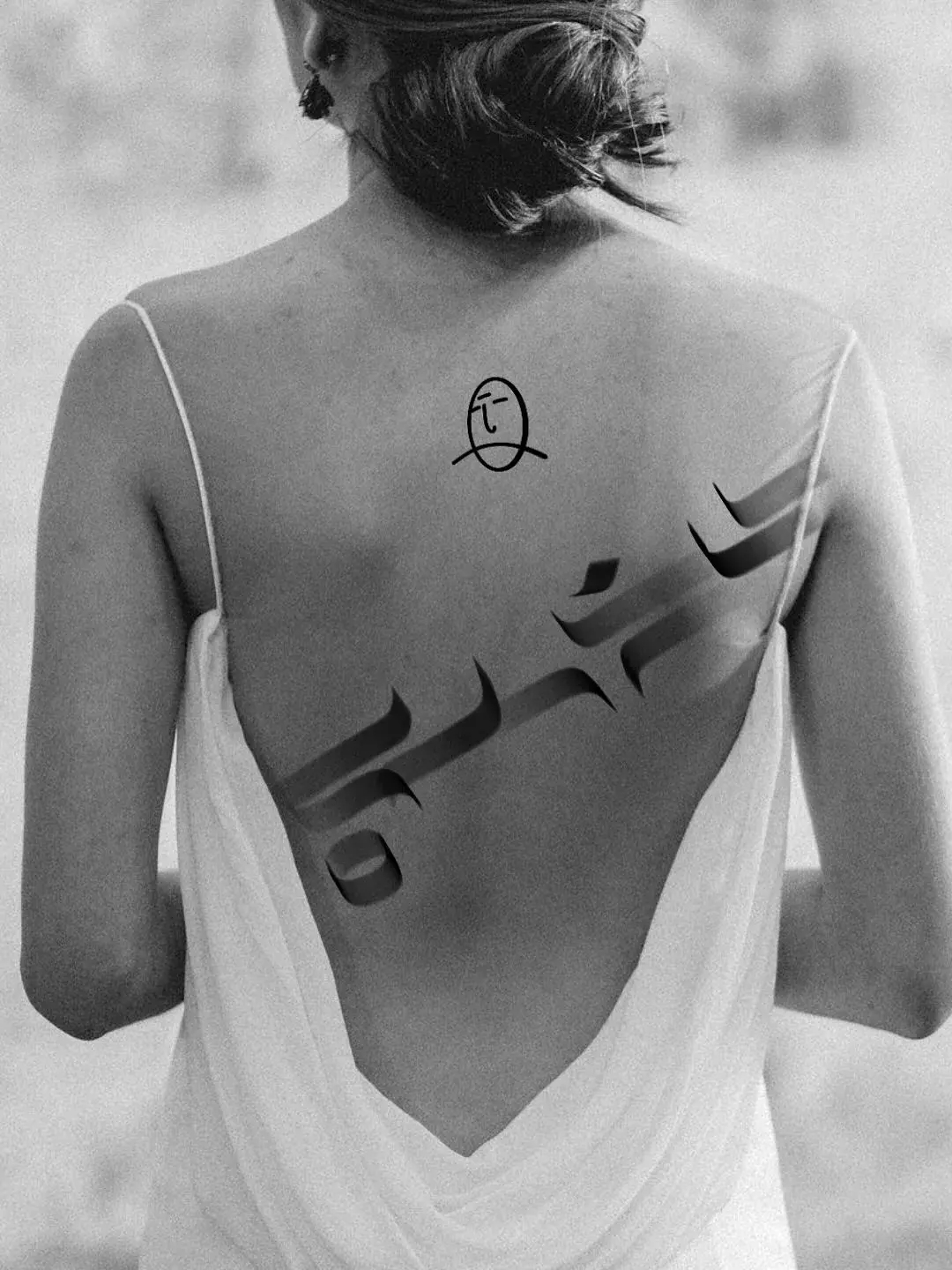 Caligrafia tatuada nas costas com o símbolo FACE, preto e branco