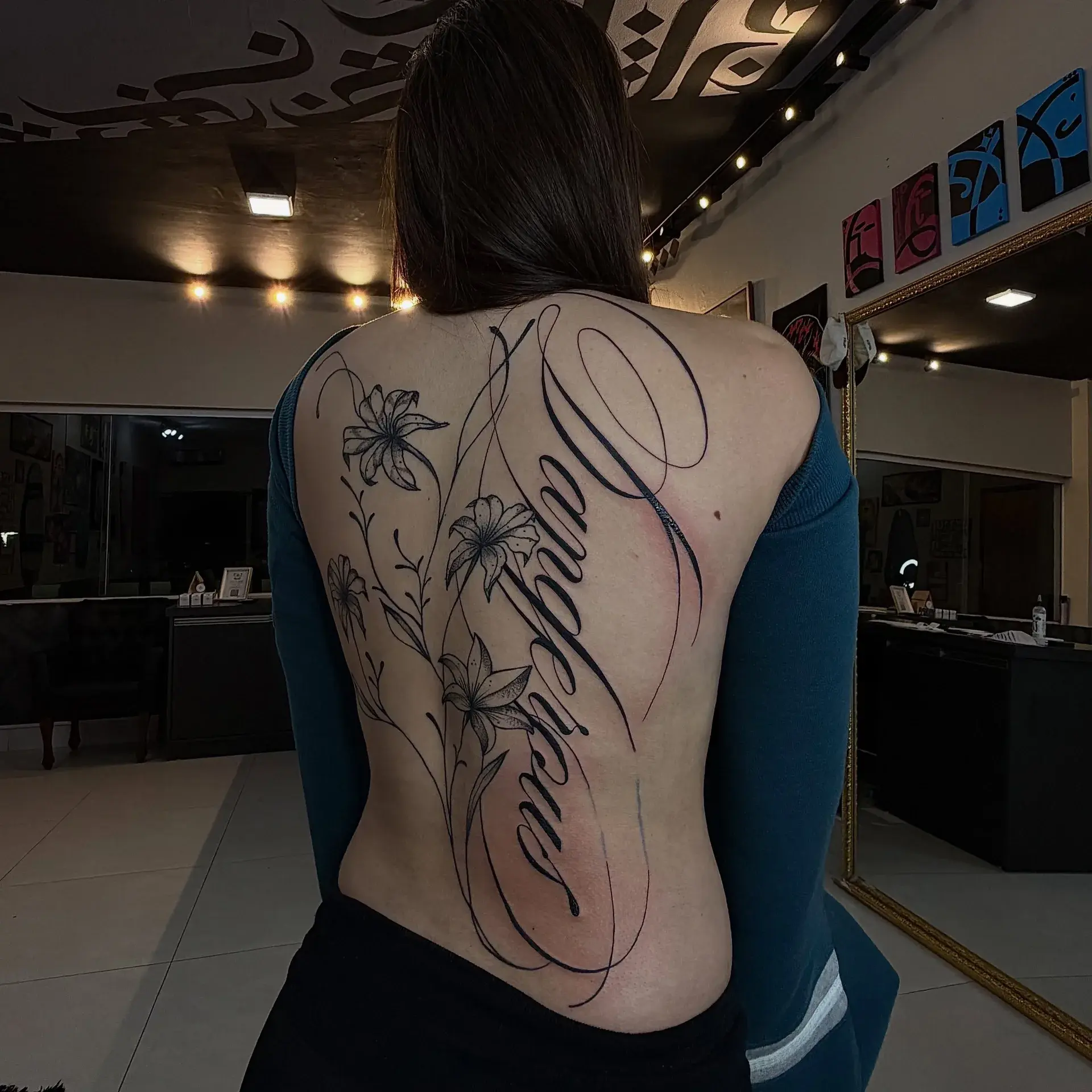 Lettering cursivo tatuado nas costas