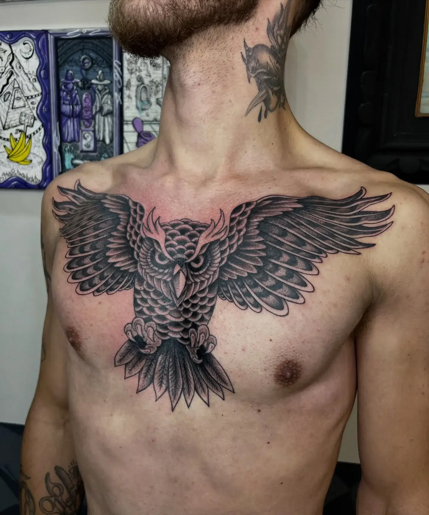 Águia de asas abertas tatuada no peito