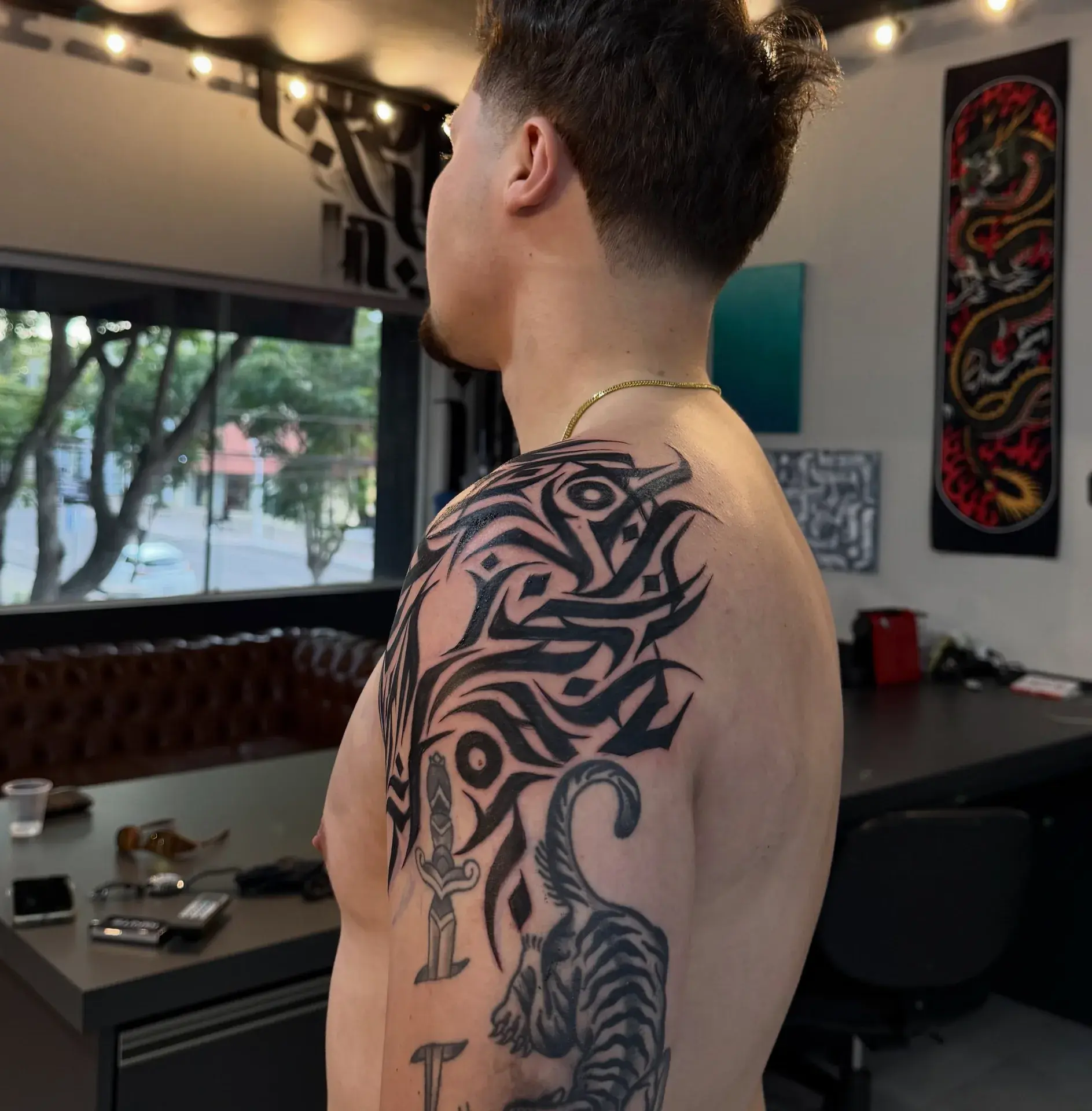 Ornamento blackwork no ombro, vista lateral