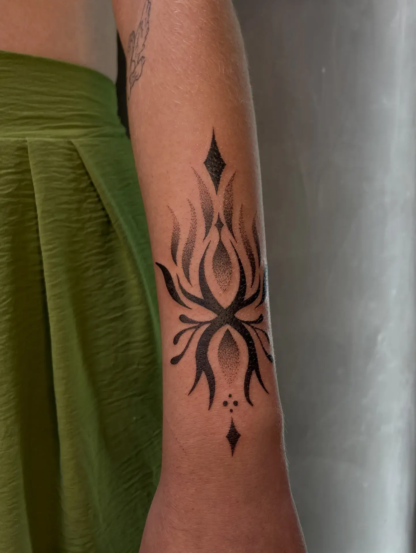Ornamento fine line tatuado no antebraço