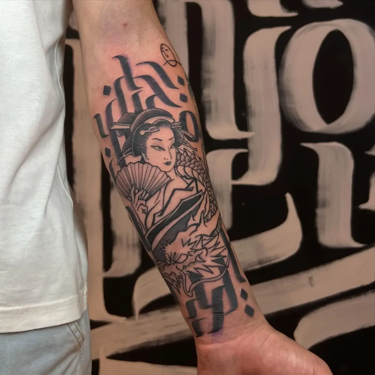 Rosto feminino e ornamentos tatuados no braço